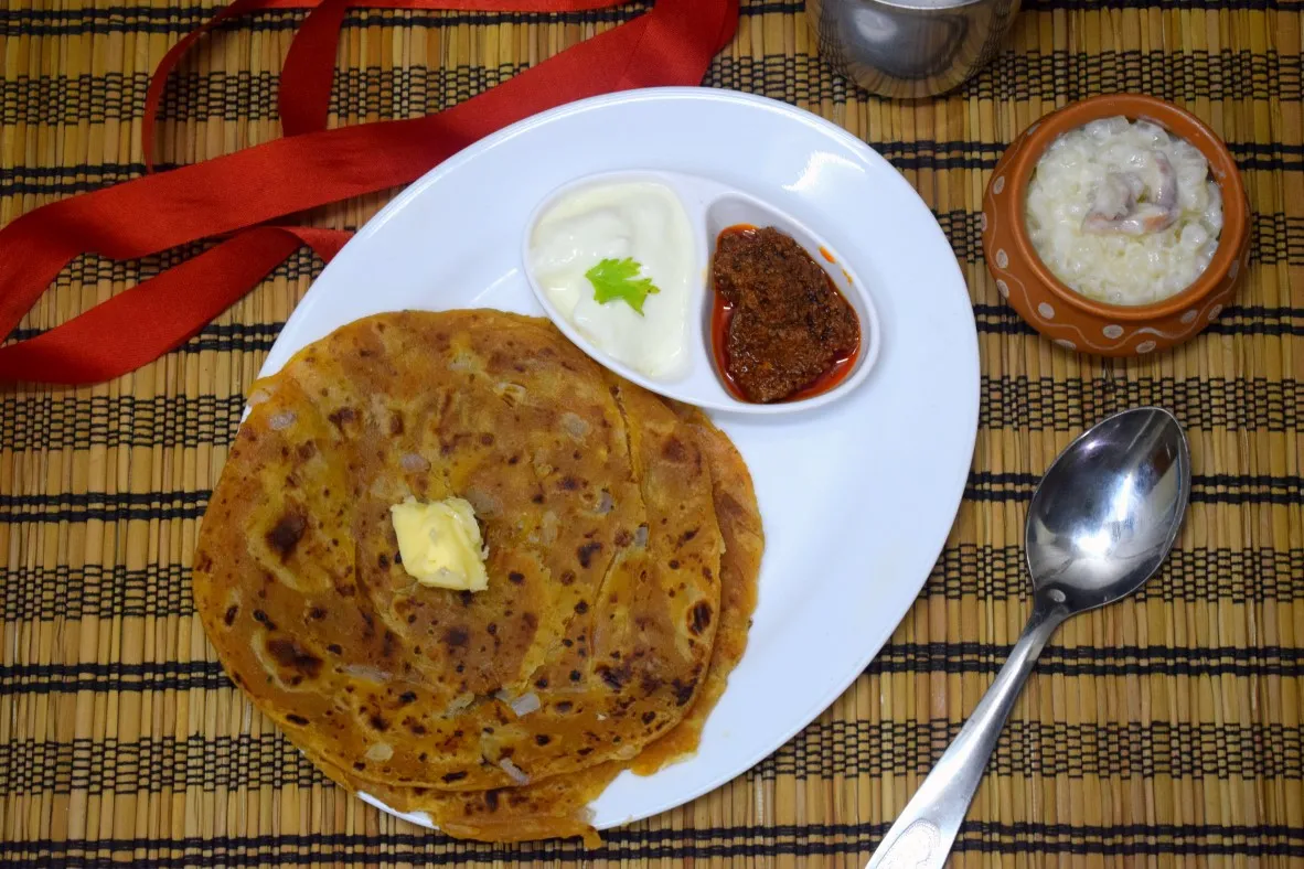 Breakfast spread of parathas, curd and fruits